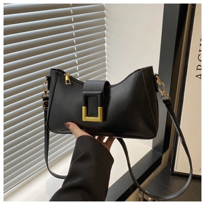 Gros plan d'un sac sous le bras en cuir noir avec boucle métallique carrée dorée vintage