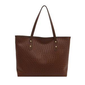 Large dark brown woven tote bag with spacious interior and gold nail hardware details