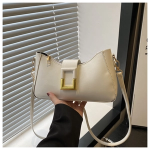 Détail du sac à bandoulière en cuir blanc crème avec boucle carrée et finitions dorées
