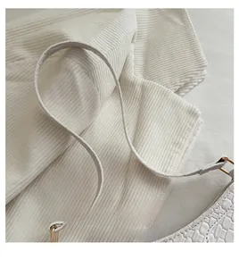 Détail du sac à bandoulière blanc crème avec texture crocodile et boucle en métal doré