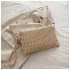Close-up of beige water-ripple texture envelope clutch bag with elegant metal zipper detail