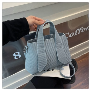 Close-up of light blue tote bag with twill woven texture and detachable shoulder strap