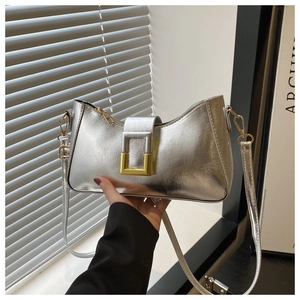 Détail du sac à bandoulière argenté métallisé avec une grande boucle dorée élégante