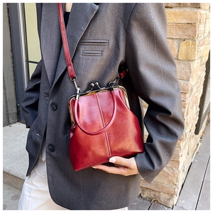 Detail of vintage burgundy doctor bag with metal clasp closure and top handle strap
