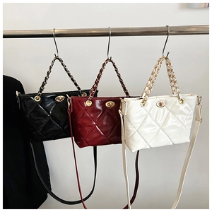 Close-up of quilted chain bags in black, wine red, and white with golden hardware