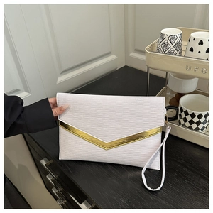 Detail of white envelope clutch bag with water ripple texture and golden V-shaped metal trim