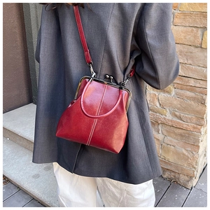 Close-up of red vintage doctor bag with retro metal clasp and lychee leather texture