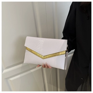 Close-up of white envelope clutch bag with golden wavy metal trim and textured leather surface