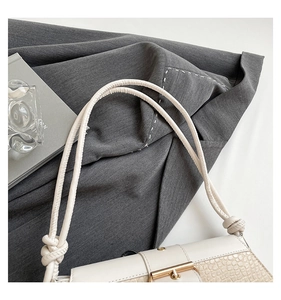 Detailed macro of beige croc-embossed leather handbag with elegant gold metal buckle closure