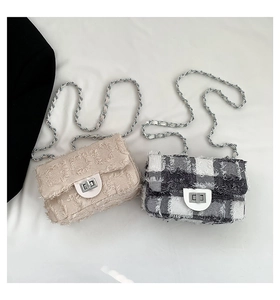 Détail de sacs bandoulière en tweed avec chaînes métalliques et bords effilochés