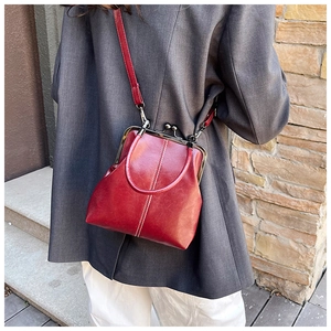 Close-up of vintage burgundy frame bag with glossy faux leather and silver metal clasp
