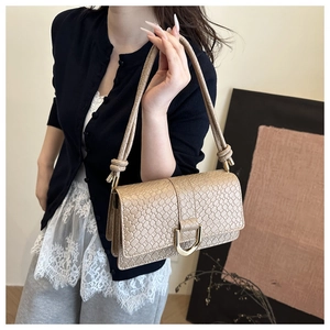 Detailansicht der beigen Tasche mit Flechtstruktur, goldener D-Schnalle und Knotendesign