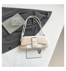 Detail of cream faux crocodile texture shoulder bag with large buckle and knotted strap
