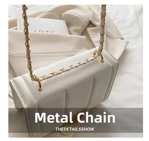 Détail du sac bandoulière beige avec matelassage plissé et chaîne en métal doré chic