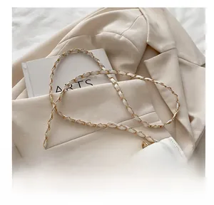 Détail du sac en cuir blanc avec bandoulière entrelacée de chaîne dorée et de cuir