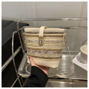 Detailed close-up of woven bucket bag featuring multi-color cords and golden metal twist lock