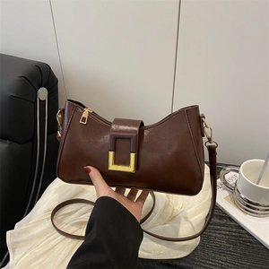 Sac à épaule élégant en cuir marron avec boucle dorée dans un style minimaliste