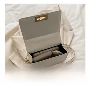 Vue intérieure du sac à chaîne crème montrant l'espace pour téléphone et maquillage