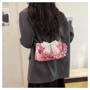 Pink metallic crossbody bag with large white mesh bow and ruffled edge detail