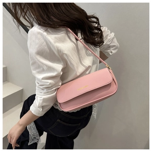 Détail du sac sous l'aisselle rose en similicuir avec lettrage doré et bandoulière