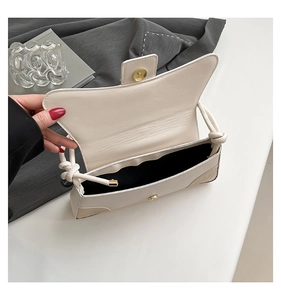Detail of off-white shoulder bag with unique twisted knot strap and magnetic buckle