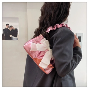 Side view of pink metallic crossbody bag with large white chiffon bow and ruffled strap