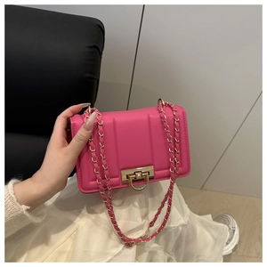 Gros plan du sac bandoulière fuchsia avec boucle dorée et surpiqûres verticales tendance