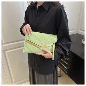 Detail of light green envelope clutch with water-ripple texture and gold metal trim