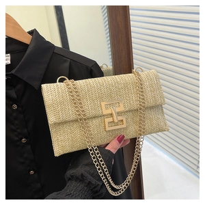 Detail of beige straw woven crossbody bag with vintage gold buckle and chain strap