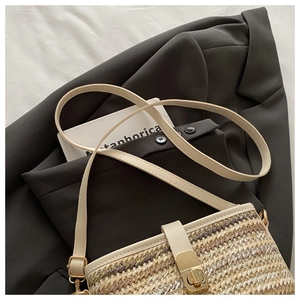 Detailed close-up of woven bucket bag featuring gold twist lock and leather shoulder strap
