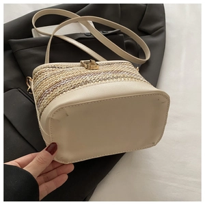 Detailed flat bottom view of beige woven bucket bag with smooth PU leather and metal lock