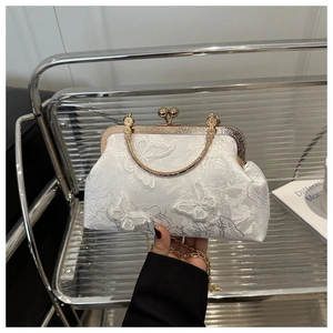 Détail du sac coquille élégant avec broderie papillon 3D et bandoulière chaîne dorée