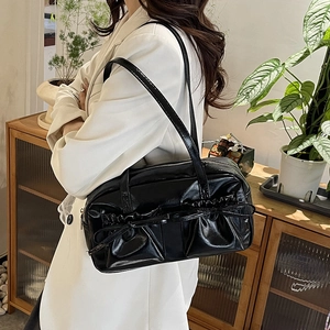 Sac fourre-tout en cuir verni noir brillant avec nœuds dans un décor intérieur doux