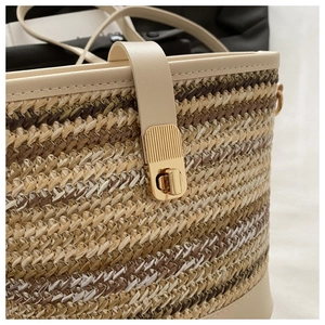 Close-up of woven straw texture and gold twist lock detail on a bucket crossbody bag