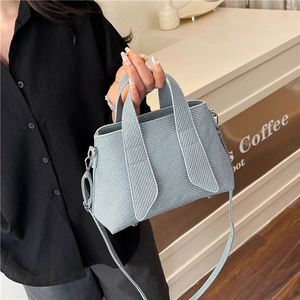 Light blue textured tote bag with stylish striped pattern and crossbody strap for women