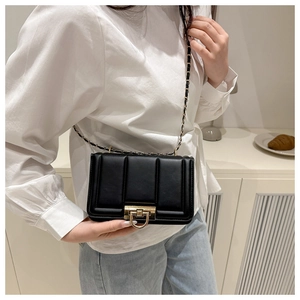 Détail du sac bandoulière noir matelassé avec boucle dorée et bandoulière en chaîne