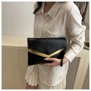 Detail of black wave texture envelope clutch with gold V-trim and wrist strap