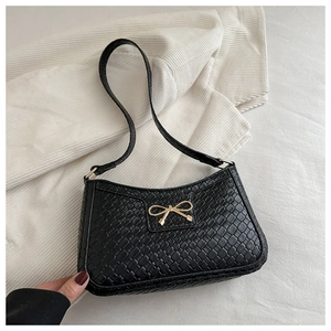 Détail du sac à bandoulière tissé noir avec une boucle décorative en métal doré en nœud