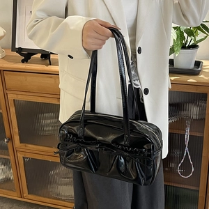 Détail du sac cabas en cuir verni noir avec poches à nœuds et fermeture éclair argentée