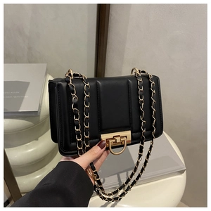Détail du sac matelassé noir avec fermoir doré et motif de couture verticale élégant