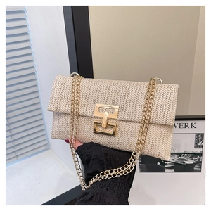 Detailed texture of beige woven straw flap bag with elegant gold metal twist lock