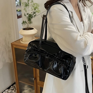 Détail du sac cabas en cuir verni noir avec doubles nœuds et texture plissée élégante