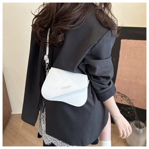 Detailed view of a white PU leather saddle bag featuring a fashion logo and adjustable strap