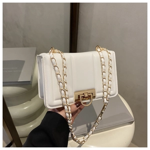 Détail du sac à bandoulière en cuir matelassé blanc avec fermoir doré et bandoulière chaîne