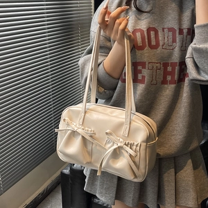 Détail de sac cabas crème avec nœuds papillon et poches avant fonctionnelles