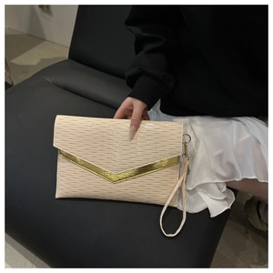 Macro view of cream white envelope clutch featuring wavy pleated texture and gold V-shaped trim