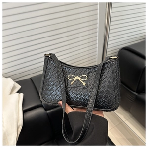 Détail du sac d'épaule noir à motif crocodile avec fermoir nœud métallique doré