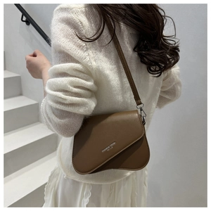 Brown crossbody bag featuring a unique asymmetrical wave flap and silver logo print