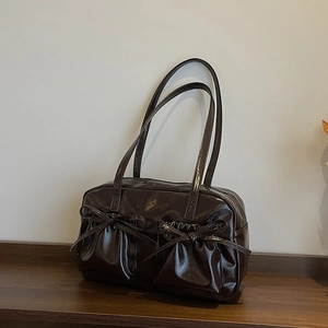 Détail du sac cabas en cuir marron foncé brillant avec poches à nœuds et bandoulières