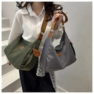 Detail of waterproof nylon crossbody bag with wide shoulder strap and metal logo